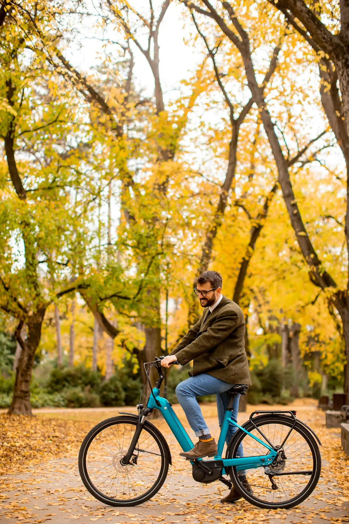 Man riding an e-bike through an autumn park